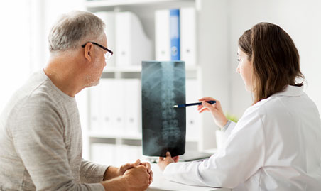 Doctor exams spine for severity of herniated disc